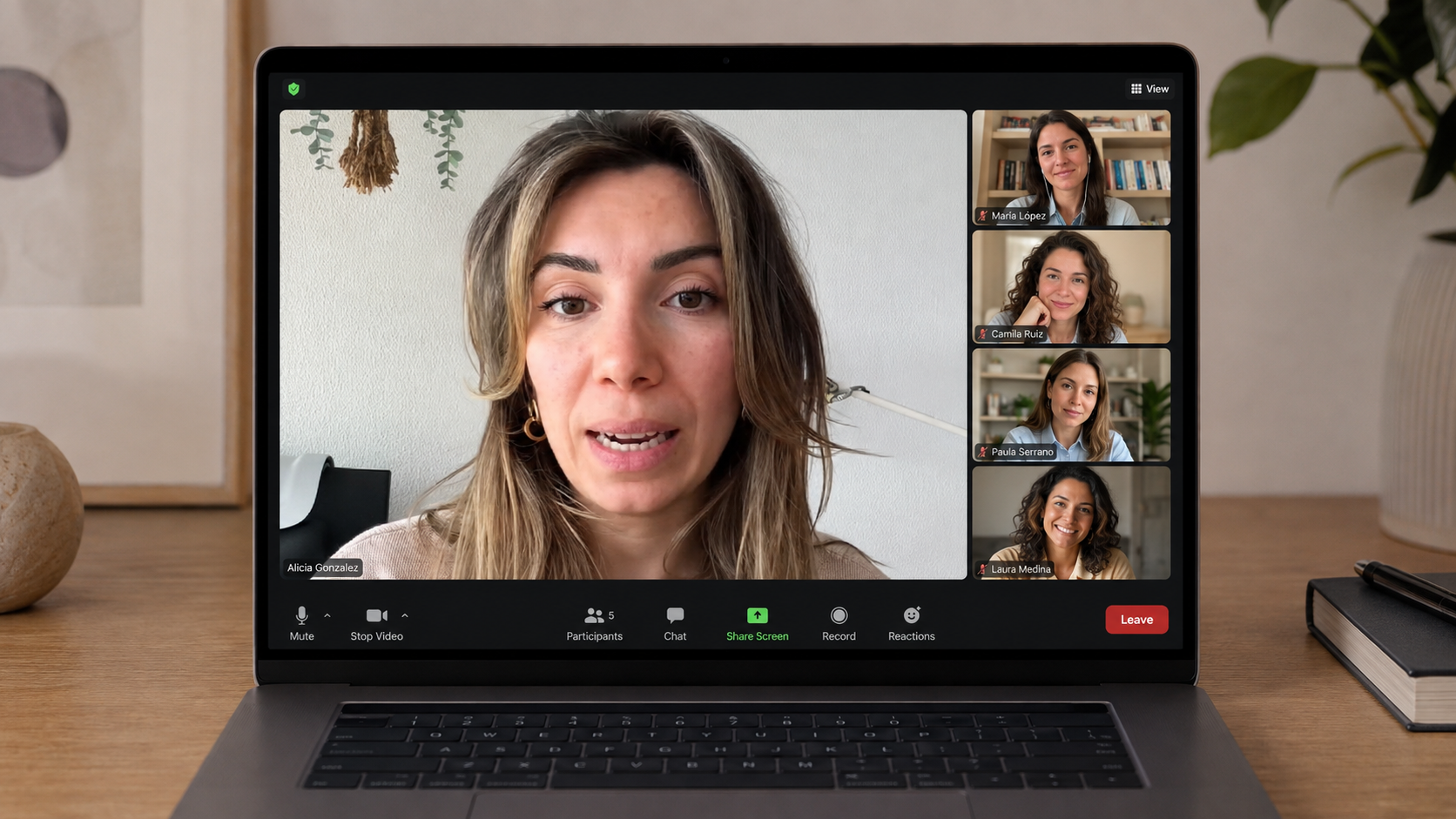 Portátil sobre un escritorio de madera mostrando una sesión en directo de Alicia González con varias participantes conectadas